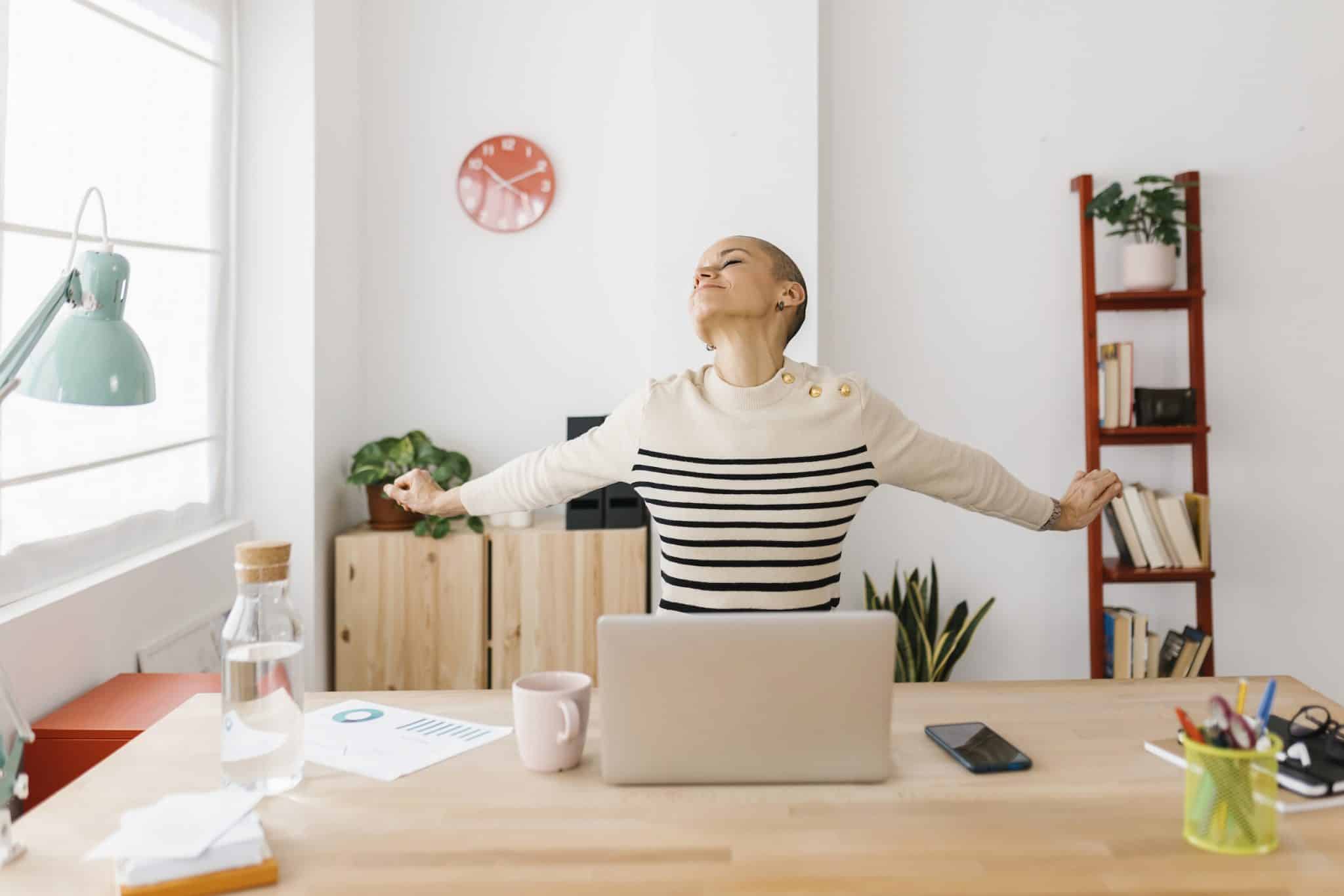 smiling mid adult woman stretching body while work 2022 08 11 00 06 11 utc scaled